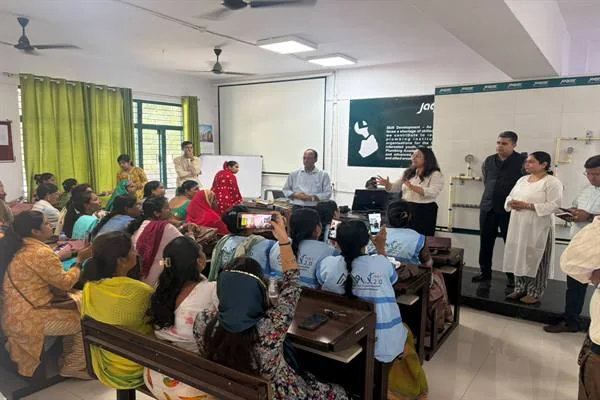 अमृत मित्र प्रशिक्षण की कक्षा में बैठी महिलाएँ और सामने जल वितरण से जुड़ी प्रस्तुति